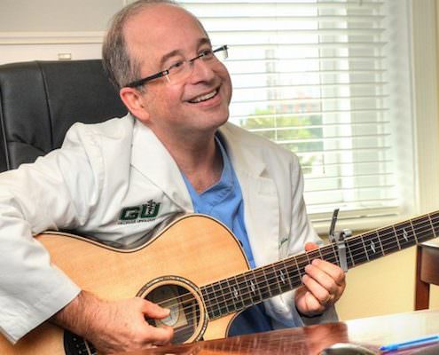 Dr. Scott Miller holding a guitar